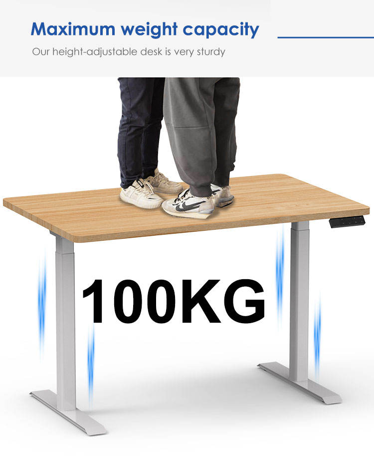 Two adults are standing on the desk to demonstrate its robust 100KG maximum weight capacity.