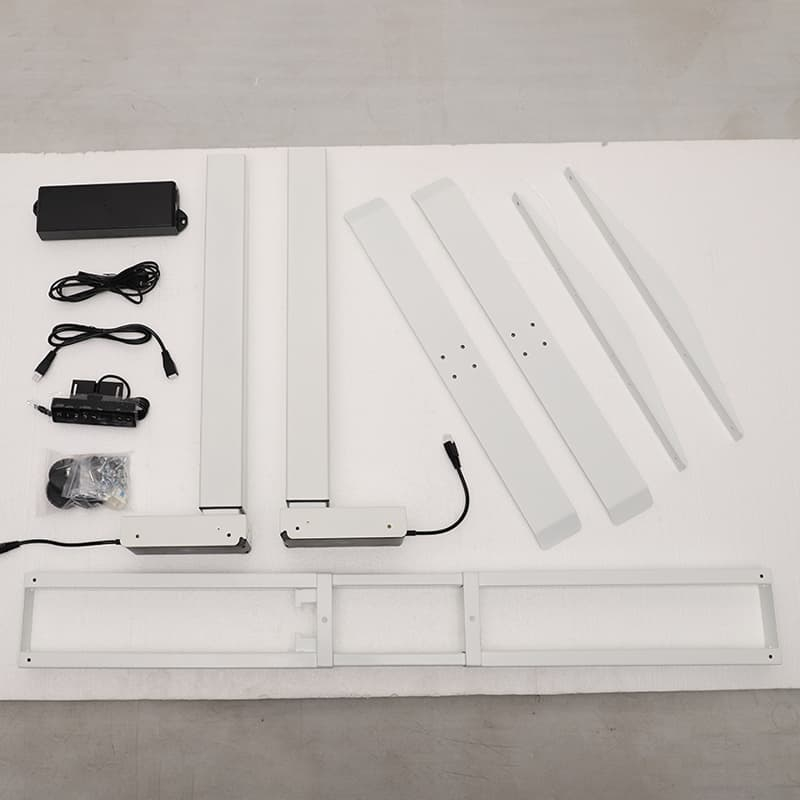 All the individual components of the white 2B2 adjustable standing desk laid out on a white surface, including legs, frame sections, control box, and cables, ready for assembly.