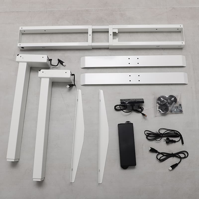 All the components of the white 2AR2 adjustable standing desk laid out on a gray floor, including the legs, feet, frame parts, control box, handset, and cables before assembly.