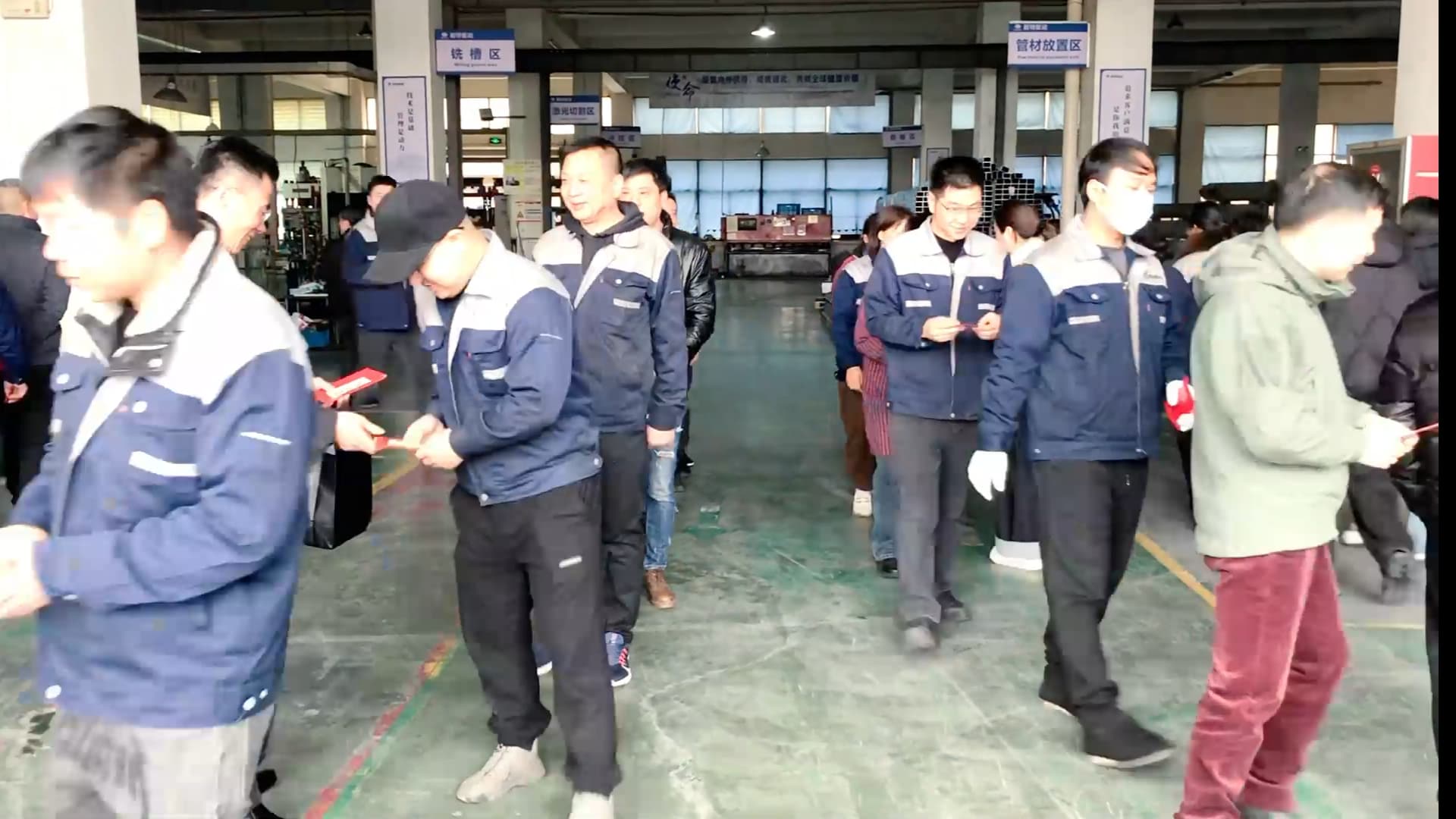 NATE leadership handing out kick-off red envelopes to factory workers